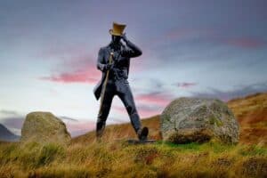 Promotional statue of Johnnie Walker Striding Man in outdoor mountain setting