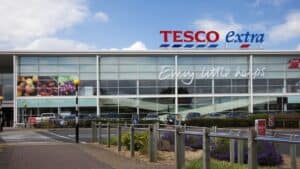 "Altrincham, UK - July 7, 2012: Tesco Supermarket sign, logo and slogan on the store in Altrincham, Cheshire, UK. Tesco is a multinational retailer of groceries and general goods, and is based in the UK. They are the second-largest retailer in the world measured by profits. Tesco Extra stores are larger hypermarkets selling a wide range of goods."