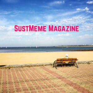 Solitary person (male) sat in sun hat on bench, looking away from viewer out to sea across sandy beach; with SUSTMEME MAGAZINE written in upper case in pink against blue summer sky.