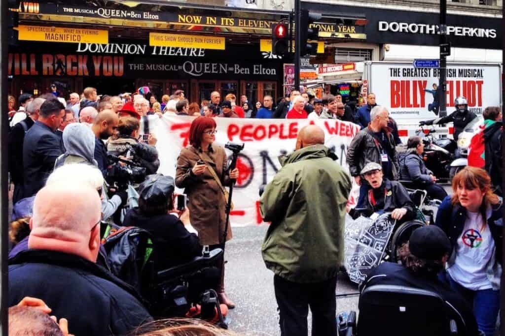 Crowd of protesters with banners in London street.