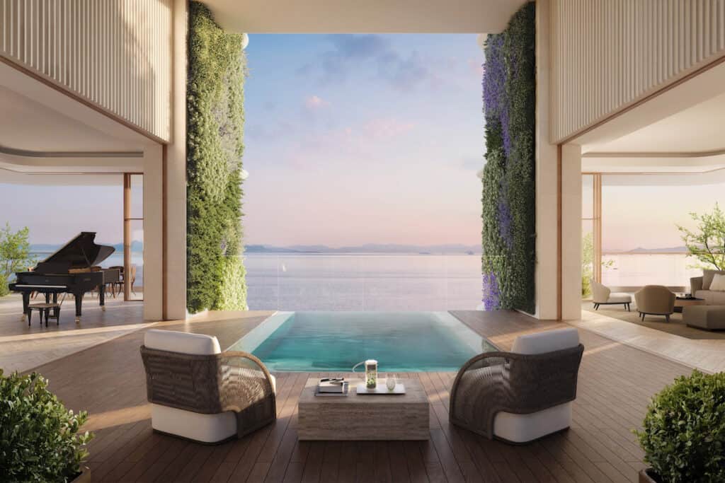 Artist's impression of interior of luxury apartment in Riviera Tower, with pair of club seats and table in middle, looking out to sea over infinity pool.
