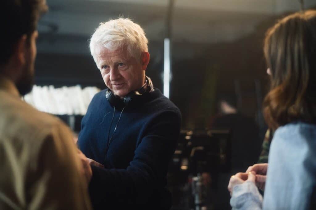 Close-up of Richard Curtis giving direction to actors.