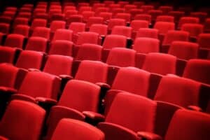 Raked red auditorium audience seating, viewed unoccupied from in front.