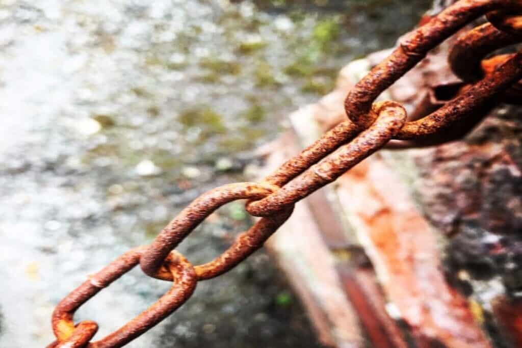 Close-up of rusty metal chain running from bottom left to top right.