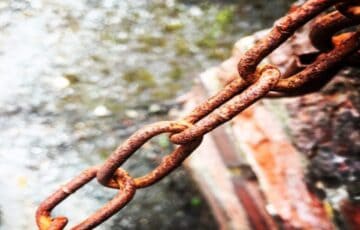 Close-up of rusty metal chain running from bottom left to top right.