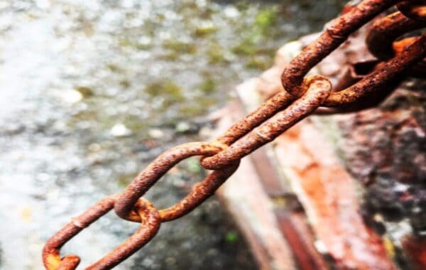 Close-up of rusty metal chain running from bottom left to top right.