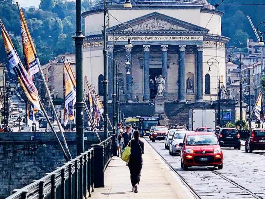 Ponte Vittorio Emanuele I bridge over river Po, in Turin, looking towards church of Gran Madre di Dio, with pedestrians, cars and tram tracks.