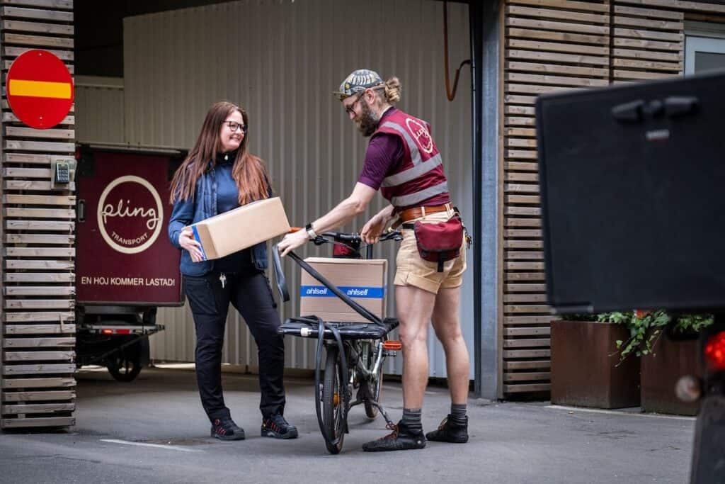 Pling delivery courier and colleague loading up bicycle with boxes.