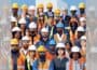 Square graphic via ChatGPT of large diverse group of construction workers standing raked in high-vis and hard hats, with faded partial duplicate panels added left and right to make image landscape.