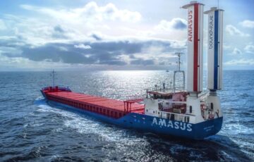 Large Amasus-branded Eems Traveller cargo ship pictured at sea, with pair of vertical suction sails to stern.