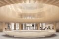 Exposed ribbed wooden structure creates circular atrium feature above equally large ring-shaped furniture piece in lobby area.