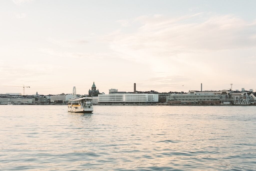 Helsinki waterfront, with new white wooden building on right of Uspenski orthodox cathedral, plus small passenger ferry in foreground.