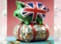 Square graphic via ChatGPT of green piggy bank with UK flag on side, atop bundle of cash notes and coins wrapped in red tape, with faded partial duplicate panels added left and right to make image landscape.