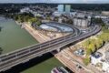 Aerial view of works to bank or river in Arnhem, with road bridge running across, plus blue and white skate park around and under carriageway.