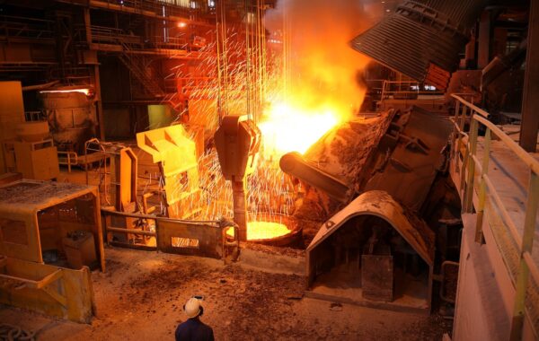 Bright orange glow as furnace rains sparks around industrial facility.