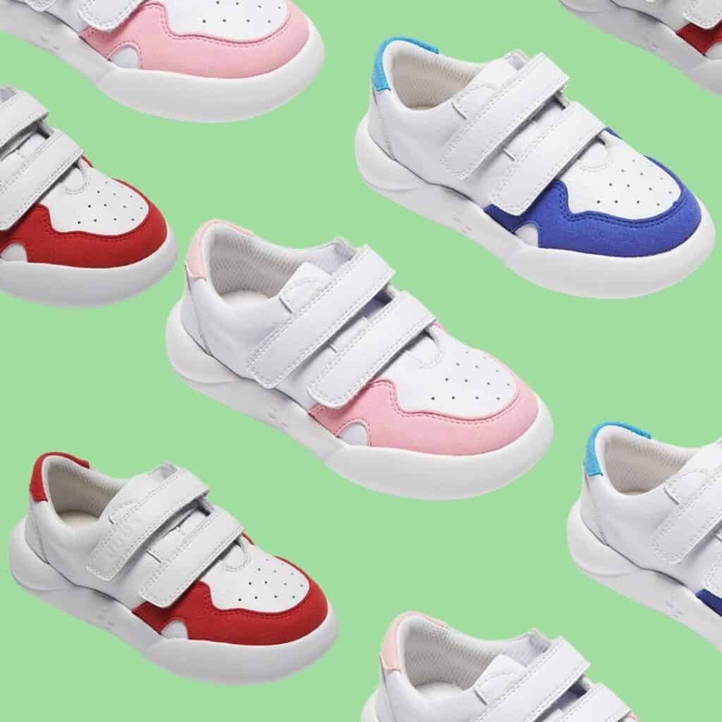 Product shot of multiple examples of Dubs Glide footwear in blue, white red and pink, arranged diagonally in rows against light green background.