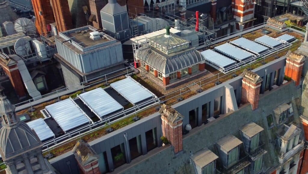 Aerial shot of Mandarin Hotel, pictured in relative close-up to show solar thermal installation in sunshine on flat roof.