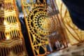 Close-up of yellow and brown spiral latticework design in sunlight.