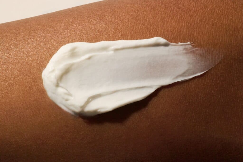 Close up of white lotion smeared on golden brown skin.
