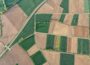 Aerial shot of patchwork of green and brown farm fields.